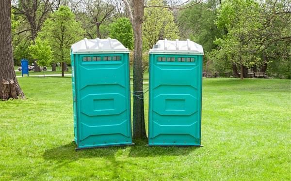 Teal portable restroom units set up for an outdoor event