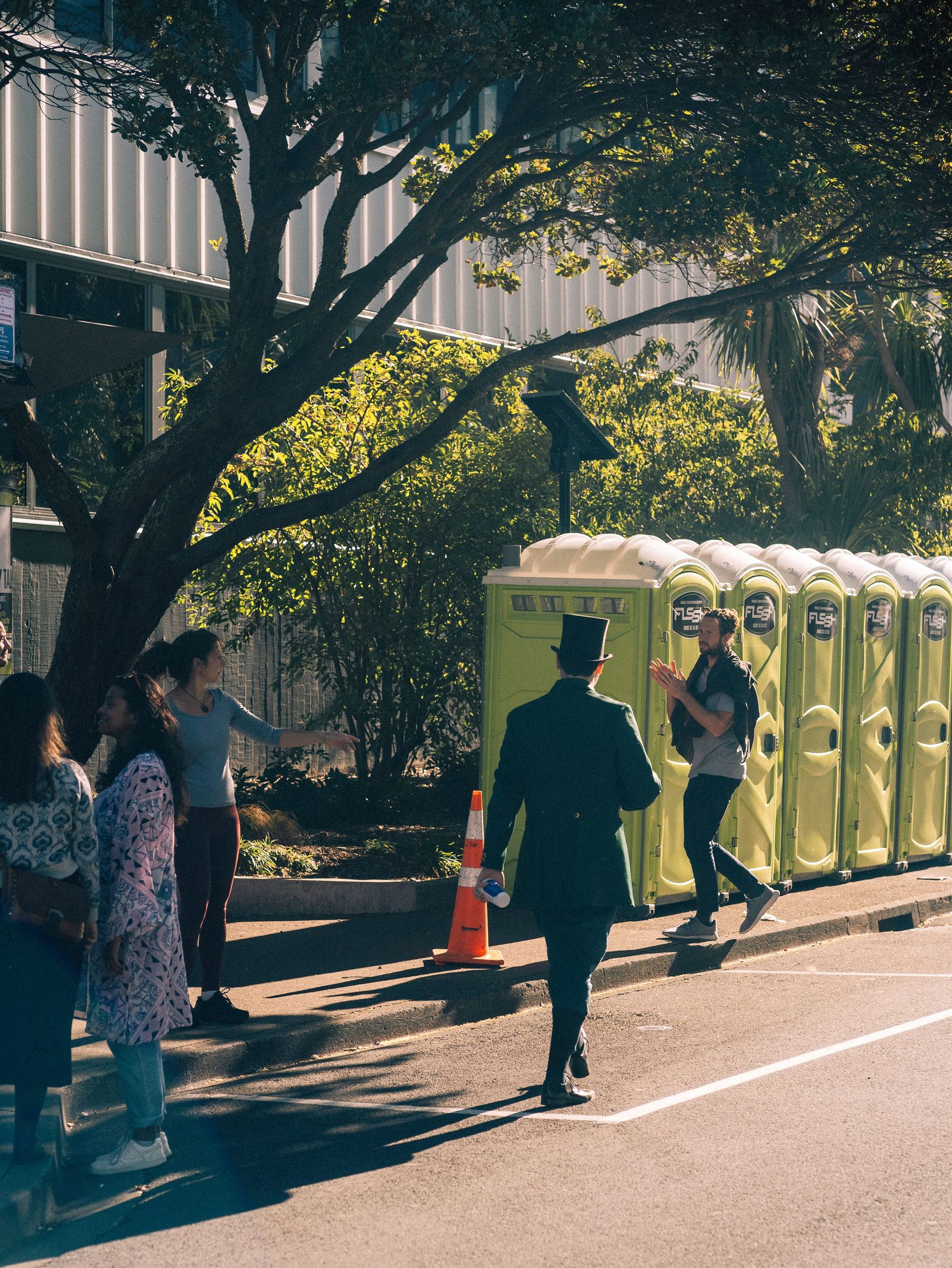 Row of orange portable restroom units at a public event